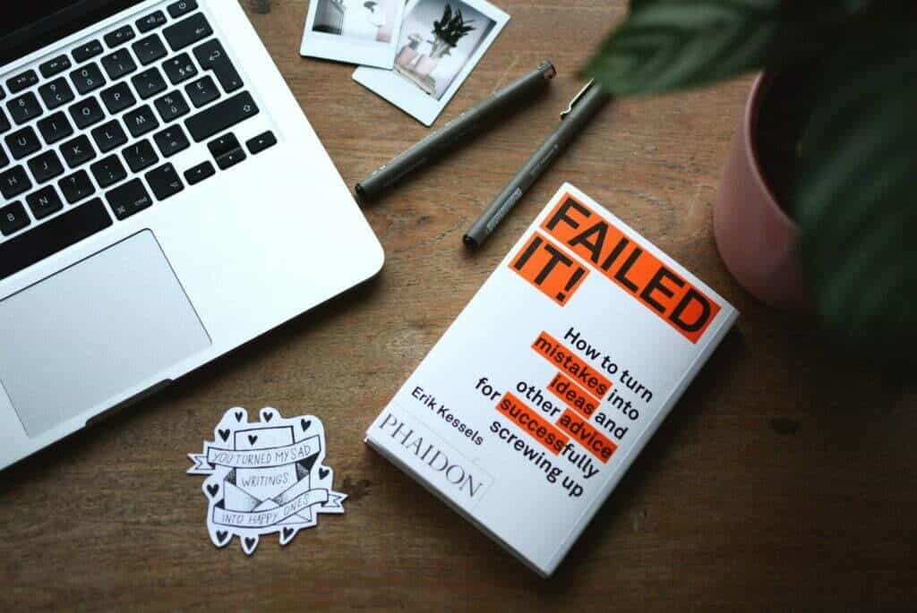 A book of fashion blogs displayed next to a laptop on a table.