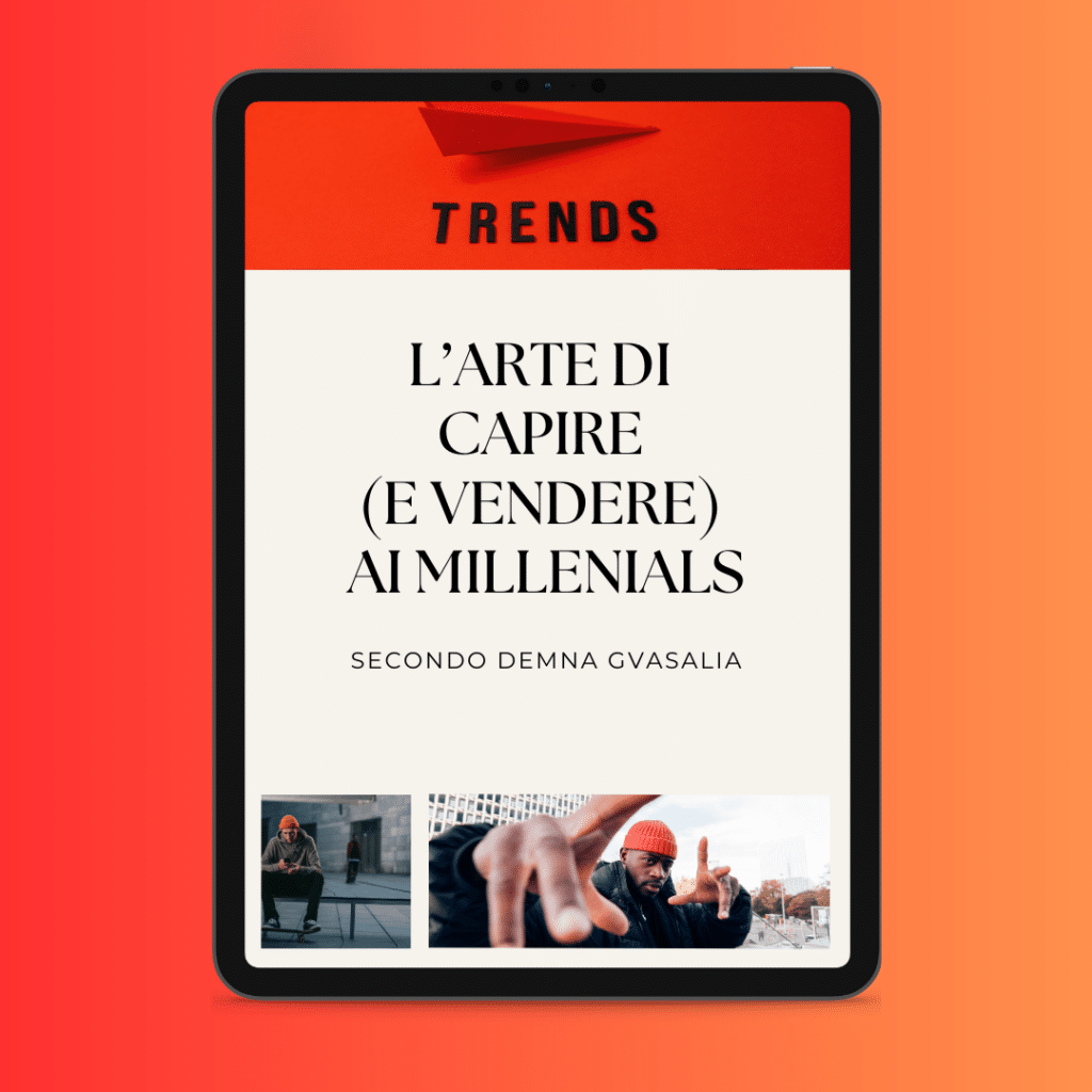L'écran d'une tablette affiche une page rouge et blanche avec le texte italien "L'Arte di Capire (e Vendere) ai Millenials" et deux photos d'individus en dessous, soulignant que tout est question de style pour surmonter la crise.