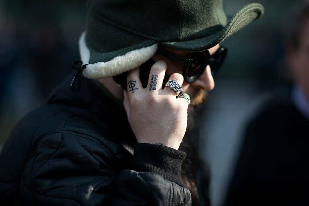 Un homme parlant au téléphone portable tout en portant un chapeau.