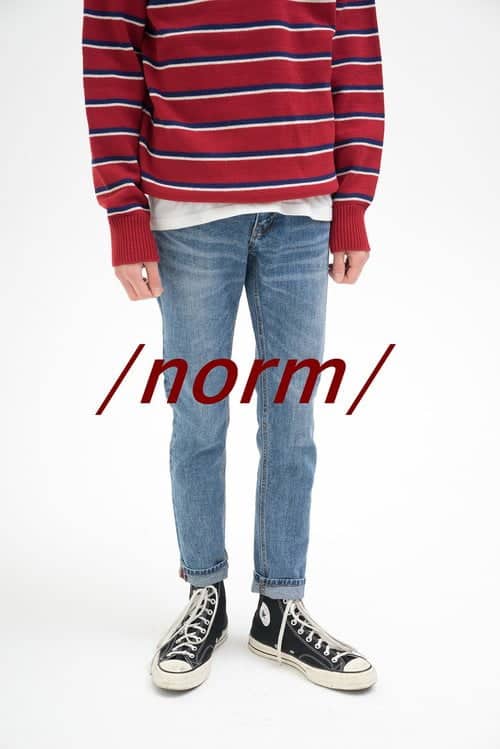 Ein Mann in Jeans und einem gestreiften Hemd mit der Aufschrift 'normal' fordert die Trendprognose heraus.