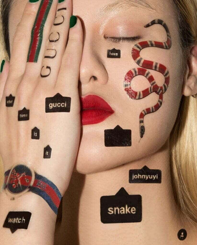 Una donna con un iconico serpente tatuato sul viso.