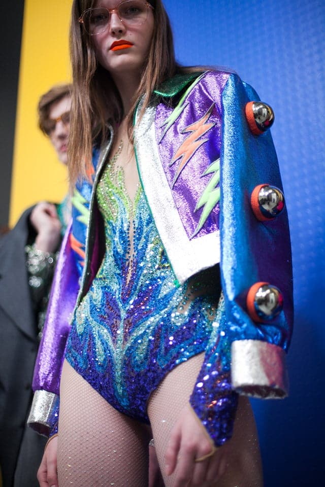 Un mannequin porte une veste colorée et des jambières.
