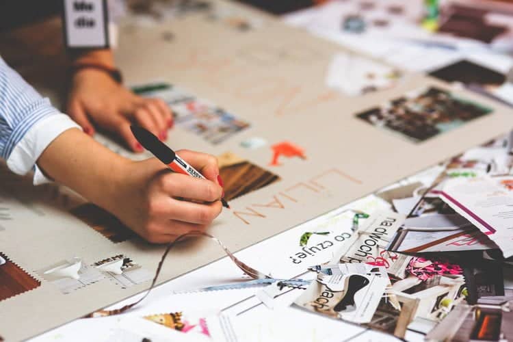 Une personne personne écrit sur une feuille de papier pour améliorer le référencement.