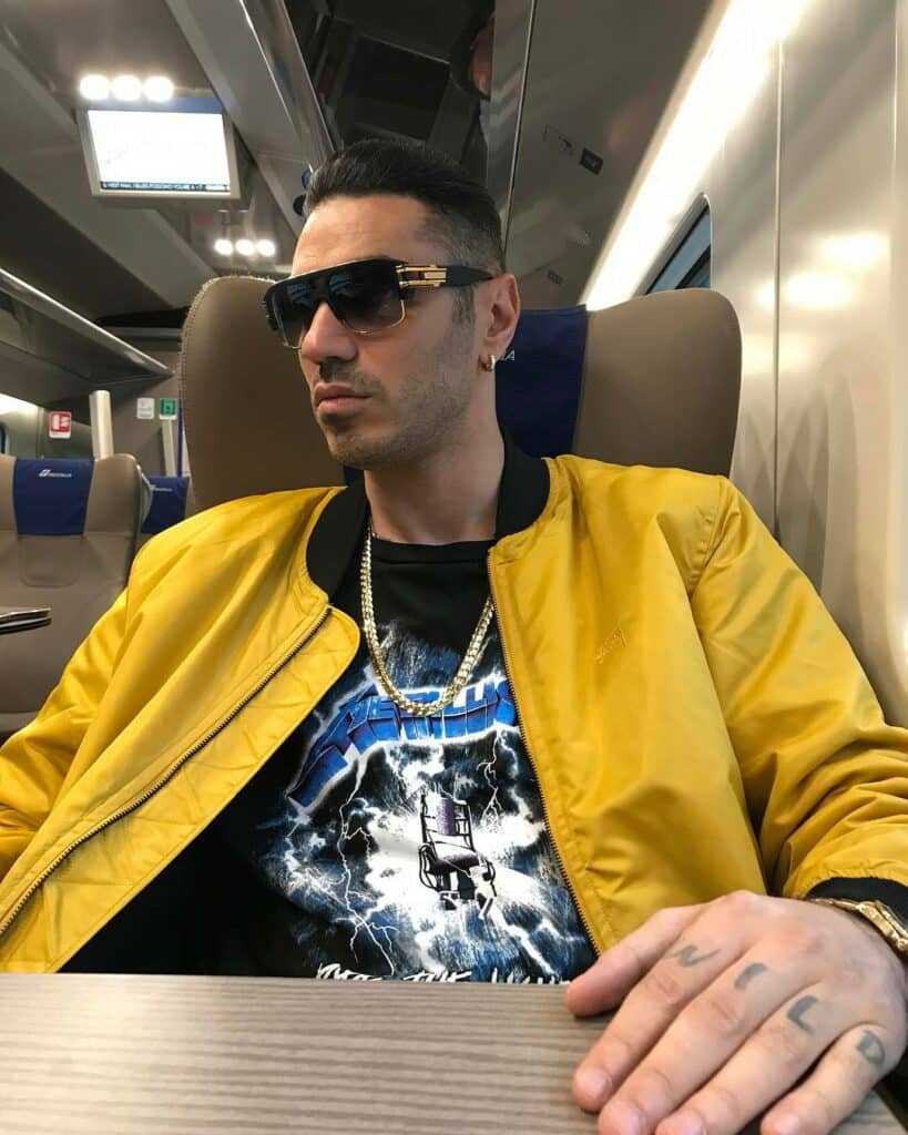 A man in a yellow jacket on a train.