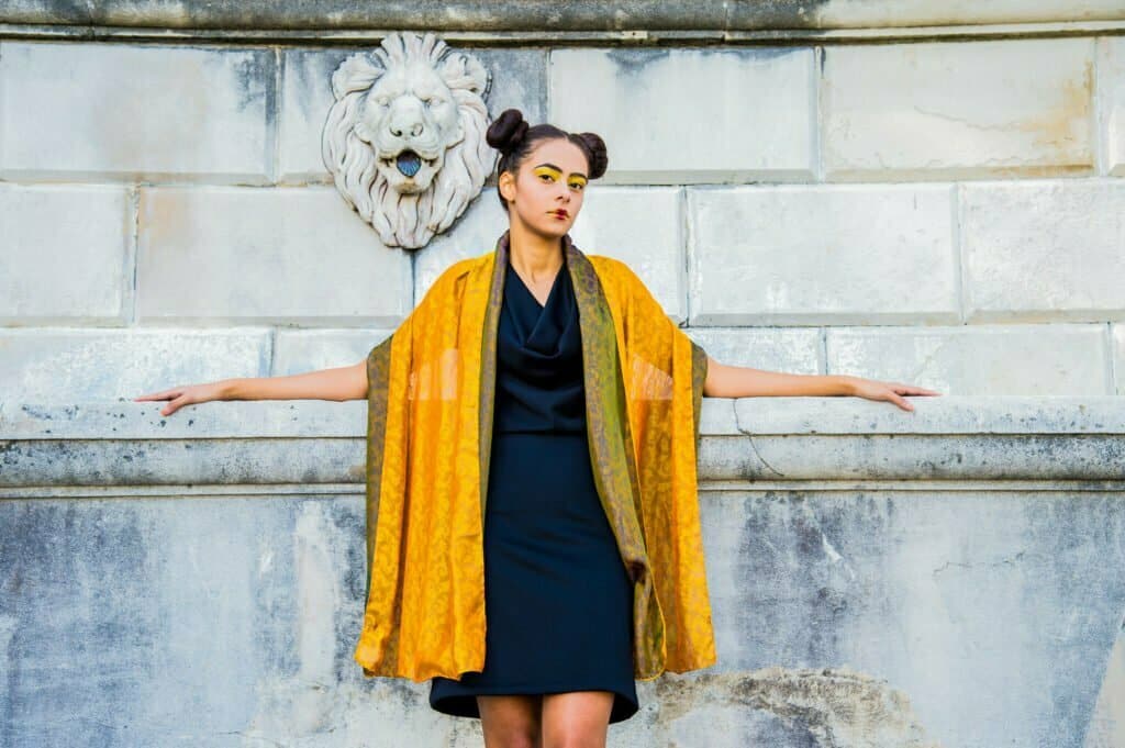 A woman with a yellow shawl @ white wall.