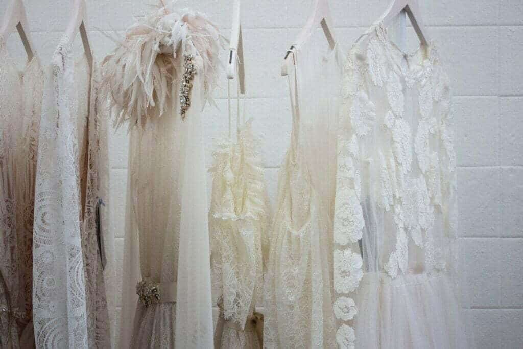 A row of white wedding dresses hung on a wall, defying the horror vacui of the corporate Instagram.
