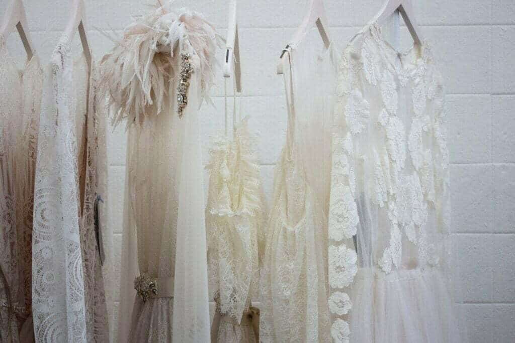 Une rangée de robes de mariée blanches est accrochée au mur, défiant l'horror vacui de l'Instagram de l'entreprise.