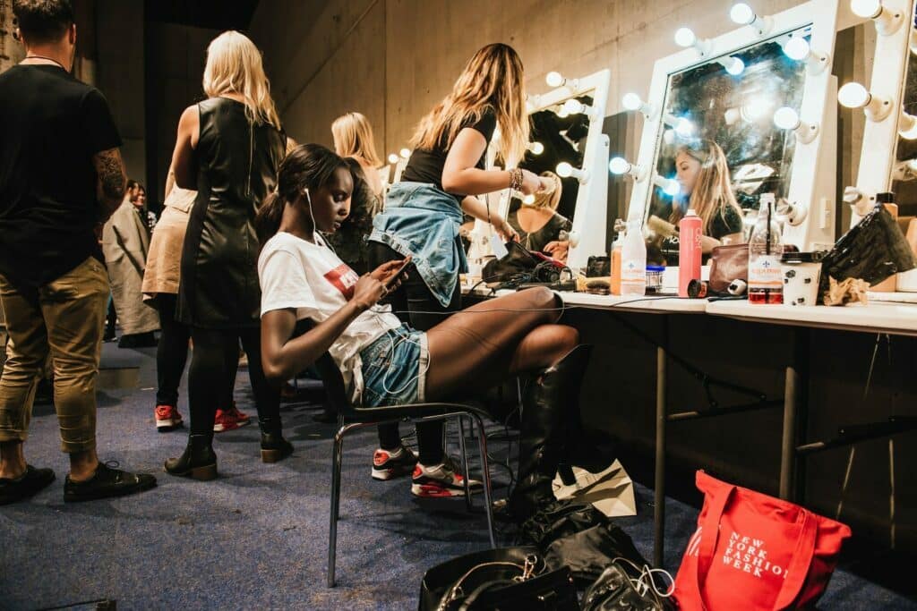 Une femme est assise devant un miroir, incarnant la résistance esthétique contre le vide oppressant de l'entreprise Instagram.