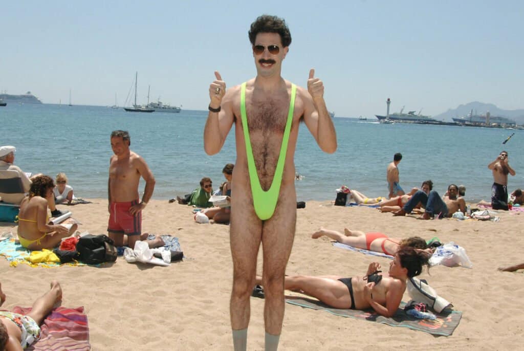 A man in a green bikini on a beach.Keywords: line, swimwear