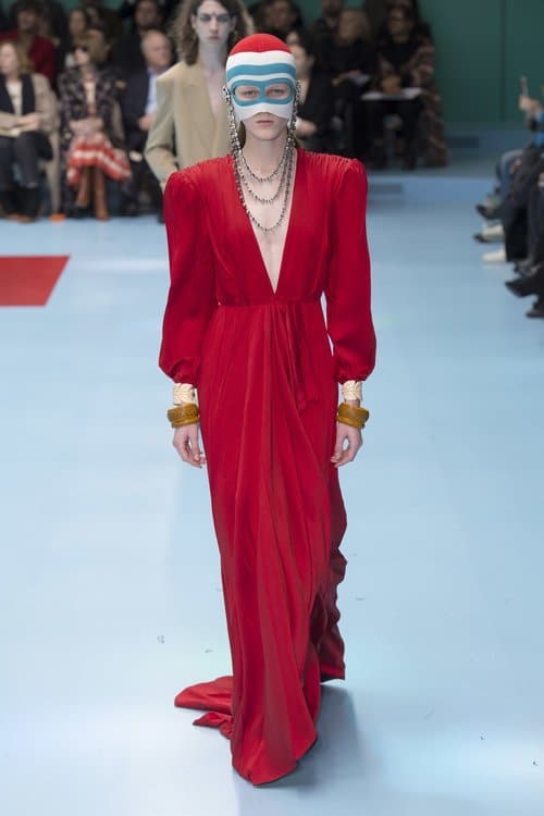 A woman in a red dress struts down the autumn-winter 2018 catwalk with an 80s party theme.