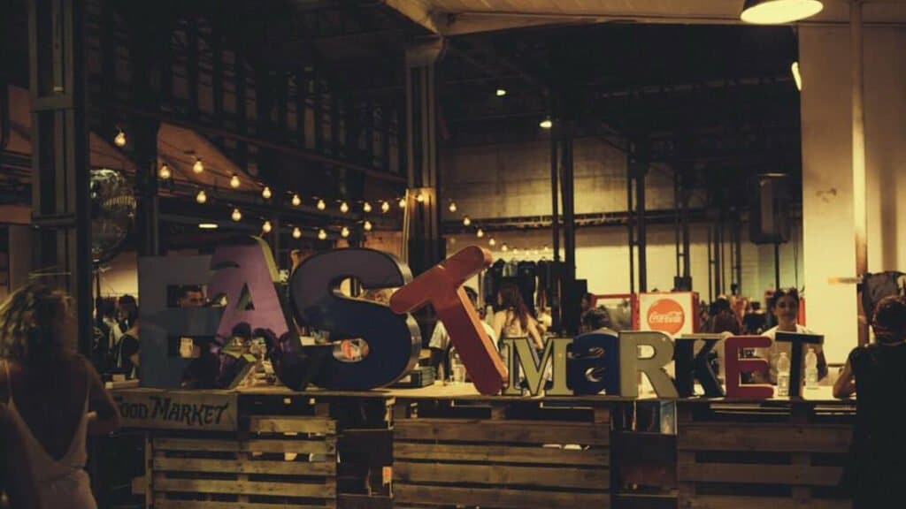 A group of people standing in front of a sign saying fast market in the fashion design industry, reflecting the changes during a Covid year.