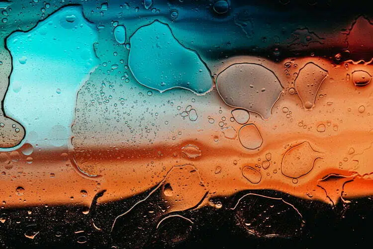 Un primo piano di gocce d'acqua su una finestra, creando un'atmosfera lunatica.