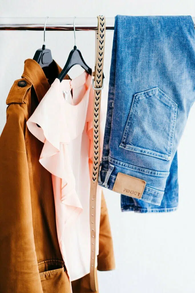 Un moodboard che mostra un paio di jeans e una giacca ispirati alla moda appesi a un rack.