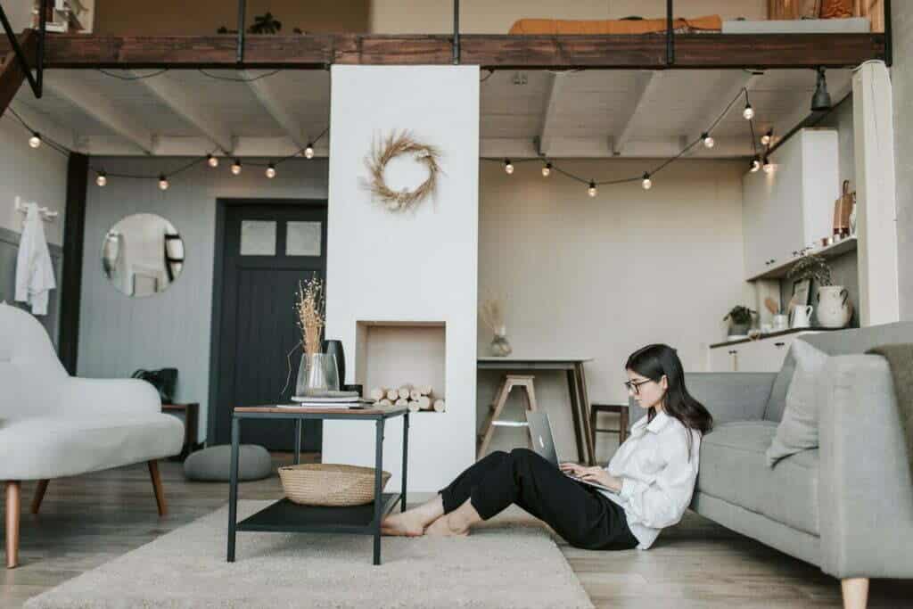 Eine Frau, die Content Marketing und Storytelling in der Modebranche einsetzt, während sie auf dem Boden eines Wohnzimmers sitzt.