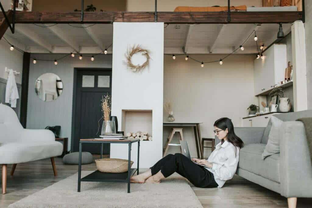 Una mujer que utiliza el marketing de contenidos y la narración de historias en la industria de la moda mientras está sentada en el suelo de un salón.