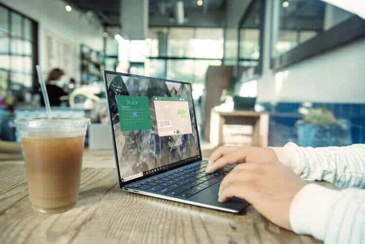 Eine Person arbeitet an einem Laptop in einem Café.