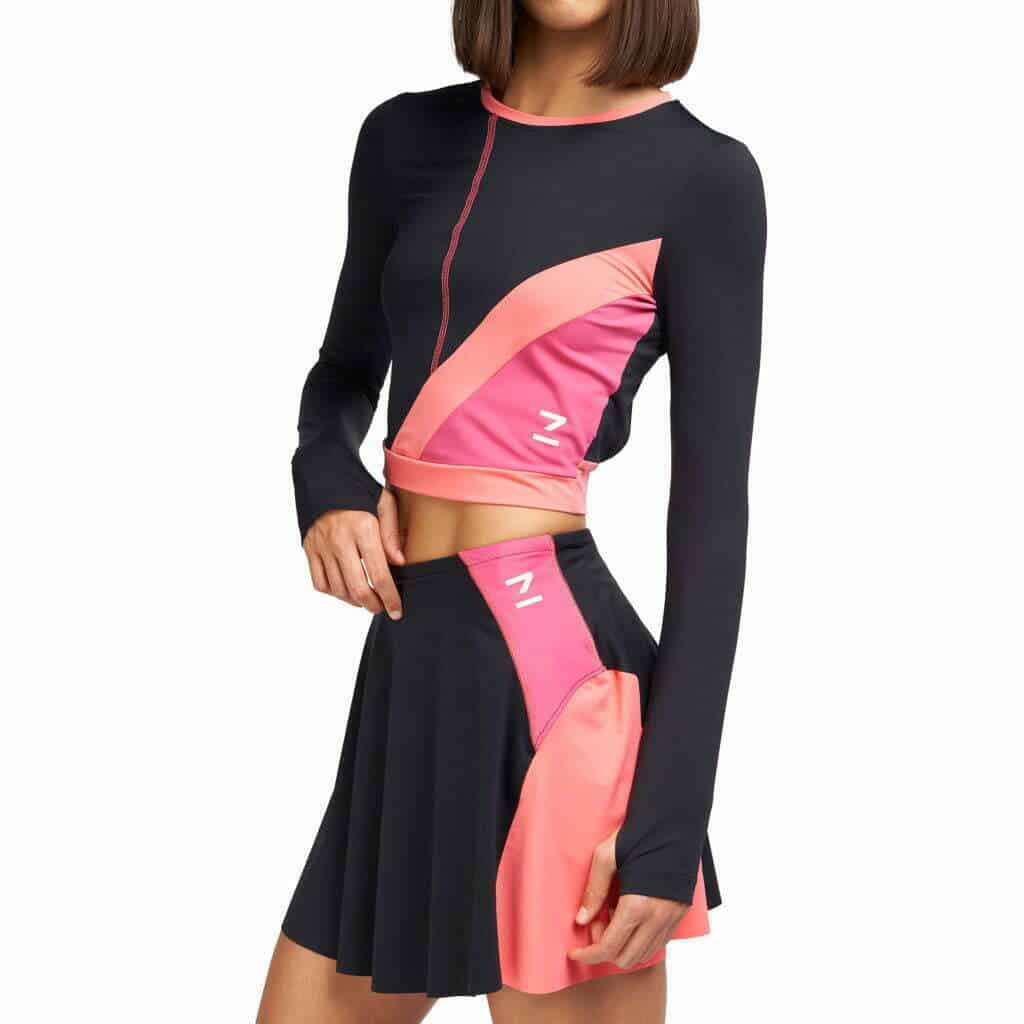 A woman poses in an elegant black and pink skirt, embodying the essence of being a fashion designer.