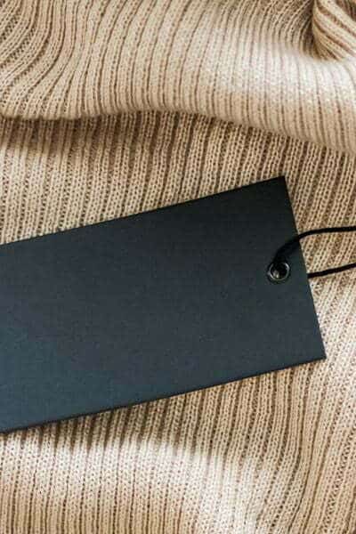 Make a fashion statement with a black label on a beige jumper.