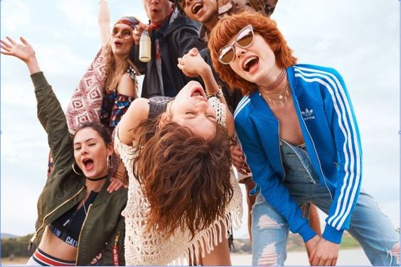 Un grupo de jóvenes a la moda posando para una foto con artículos de moda icónicos y tendencias de 2023.