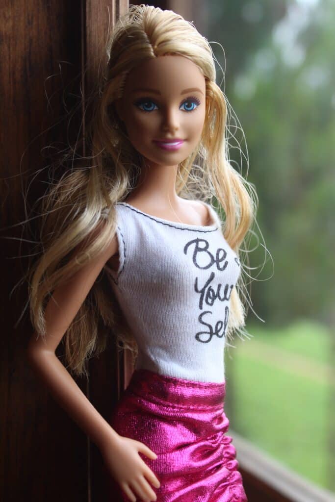 A Barbie doll wearing a pink skirt and T-shirt.