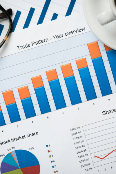 A table with graphs representing the brand's start-up consultancy with a cup of coffee.