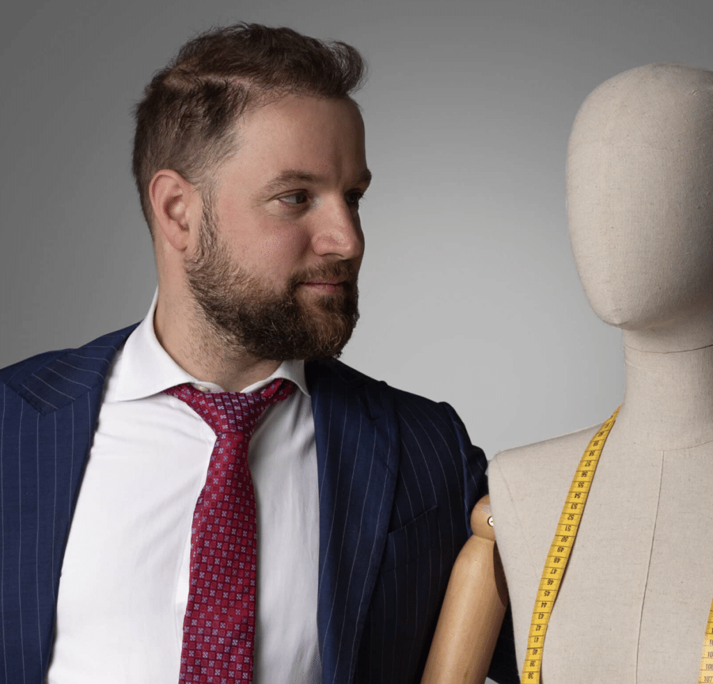 Un hombre trajeado junto a un maniquí para un blog de moda.