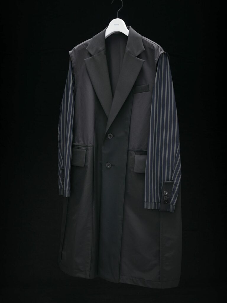 A fashionable black coat with elegant striped sleeves hung on a hanger.